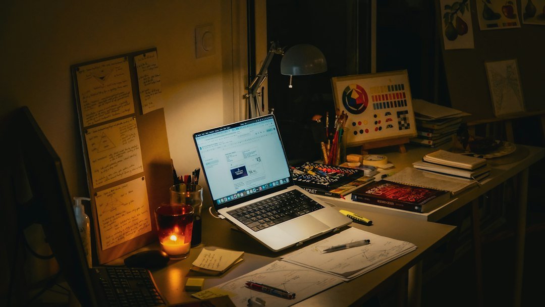 Desk with laptop, books, and lit candle