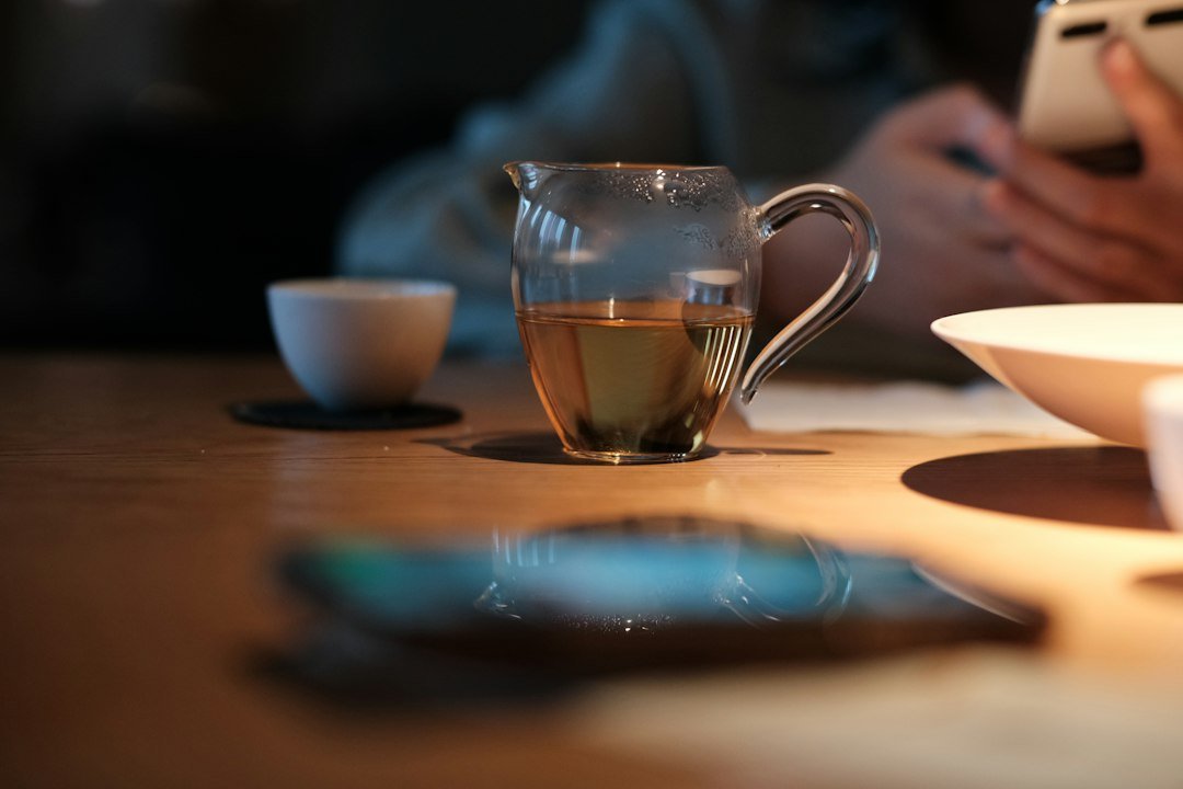 a person sitting at a table using a cell phone